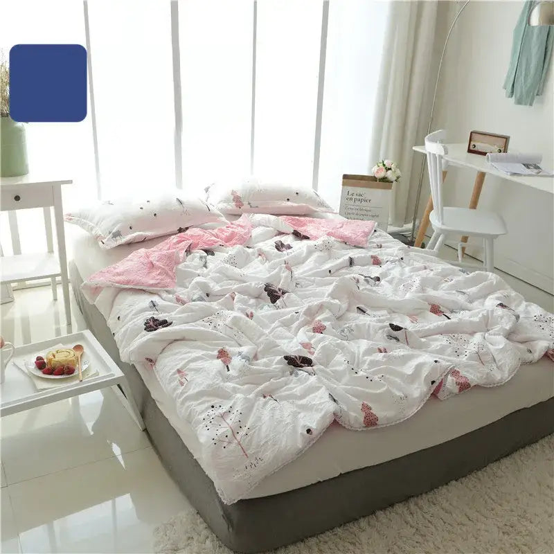 White quilted double blanket with pink and black floral patterns featuring a cartoon strawberry design for bedroom use