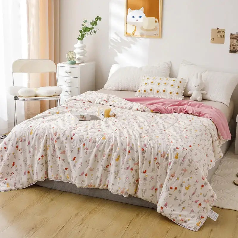 A soft off-white quilted double blanket with pastel floral and insect pattern for bedroom use