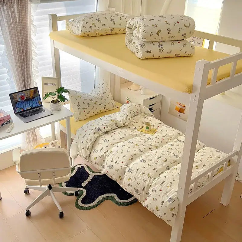 White wooden bunk bed with yellow mattress toppers and decorbites cartoon style cotton bedding sets featuring cream and blue cat print