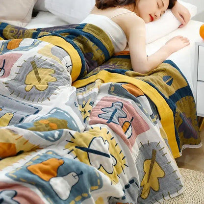 A cozy decorbites cartoon throw blanket with multicolored playful leaf and animal patterns in yellow and gray tones