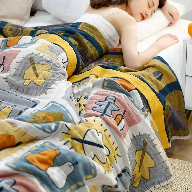 A cozy decorbites cartoon throw blanket with multicolored playful leaf and animal patterns in yellow and gray tones