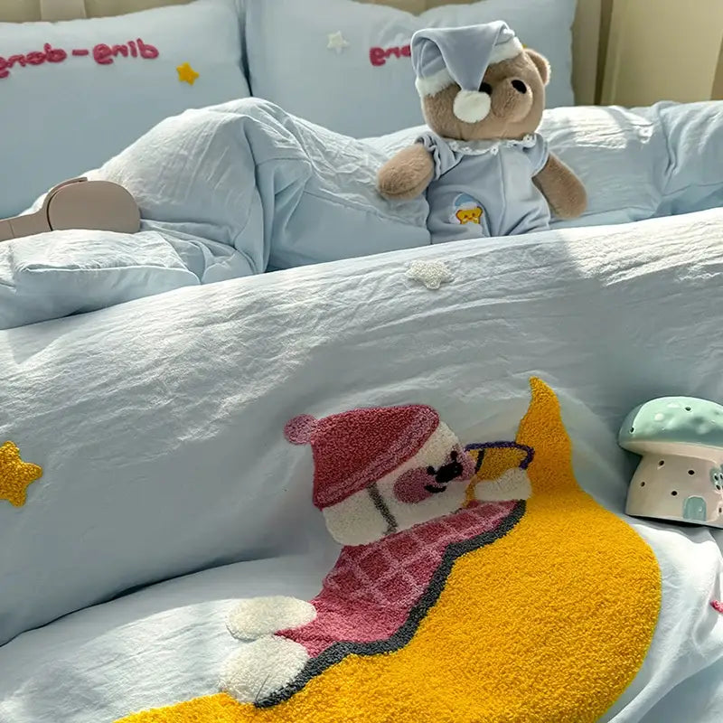 A plush teddy bear in a cartoon towel embroidery light blue bedding set wearing pajamas and sleep cap decorbites