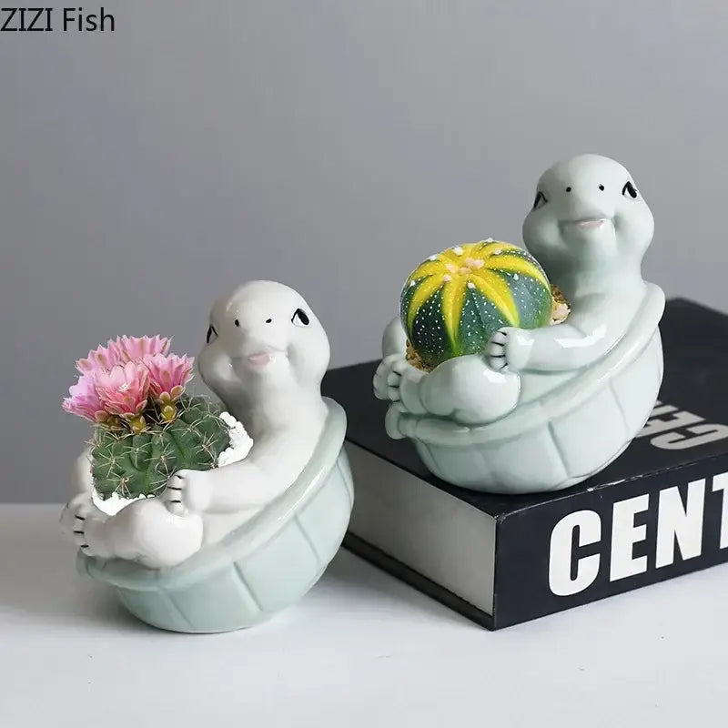 Cartoon turtle ceramic planters in soft celadon glaze with cactus featuring pink flowers and yellow green fruit decorbites cartoon turtle