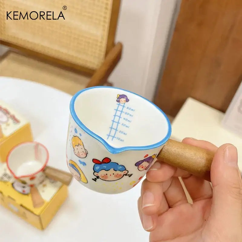 A white italian ceramic measuring cup with wooden handle and colorful cartoon decorbites italian ceramic design