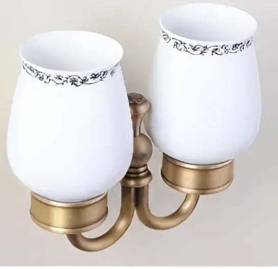 White ceramic sconce with ornate black floral trim and brass-finished arms in decorbites carved antique bronze brass bathroom hardware set