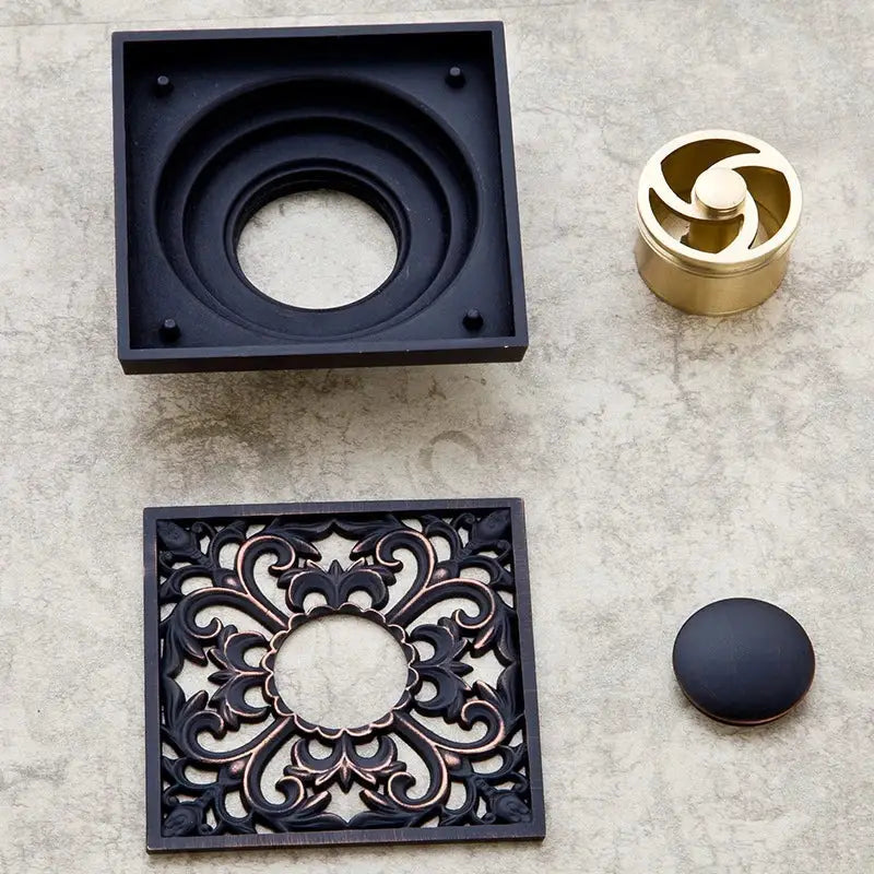 Black ornate metal floor drain cover with intricate floral design decorbites black anti-odor brass hardware