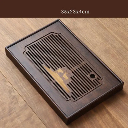 Dark brown bamboo tea tray with carved deer design and central slatted drainage area for dining room use