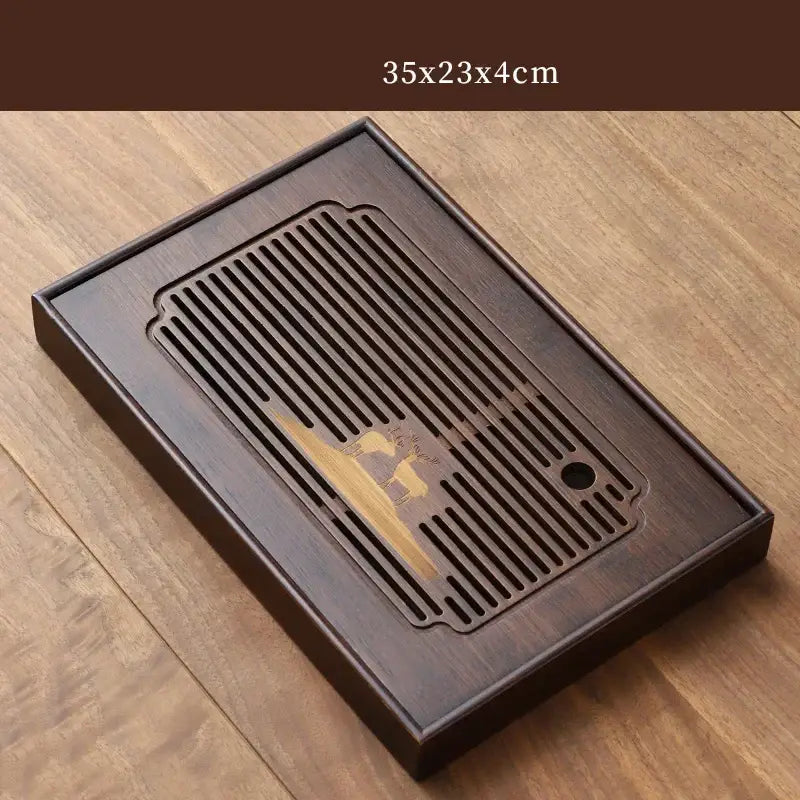 Dark brown bamboo tea tray with carved deer design and central slatted drainage area for dining room use