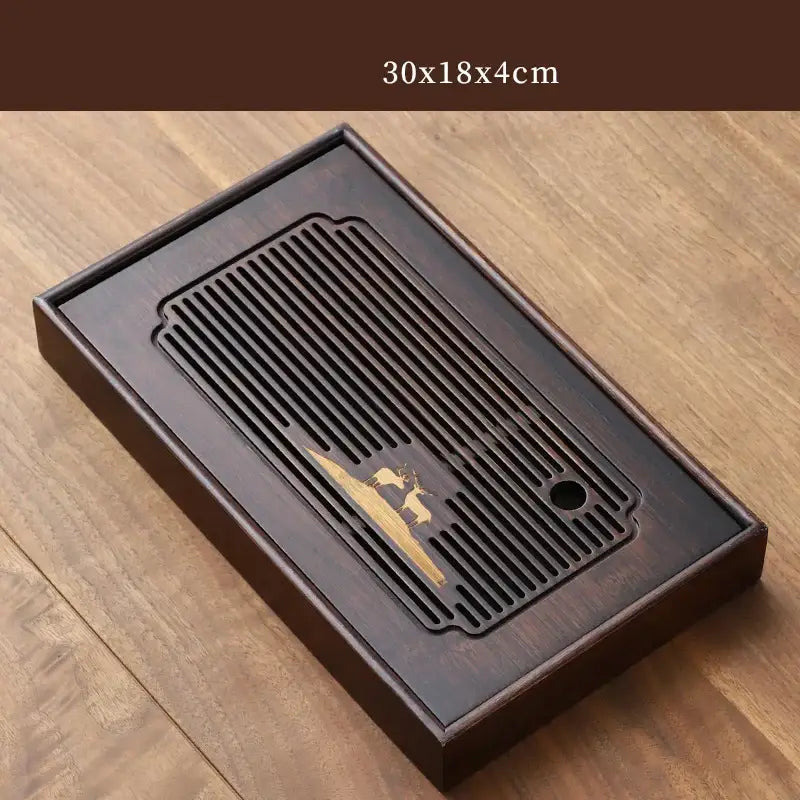 Dark brown bamboo tea tray with carved deer gold leaf design and slatted drainage area for dining room use