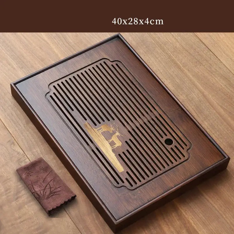 Dark brown bamboo tea tray with golden deer engraving and slatted drainage area for dining room use