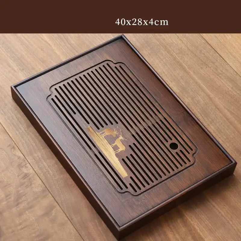 Dark brown bamboo tea tray with carved deer design and vertical slits for drainage in dining room use