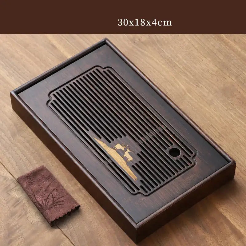 Dark brown bamboo tea tray with carved golden deer design and slatted drainage board for dining room use