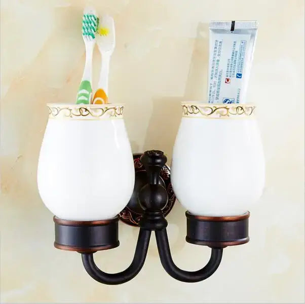 White ceramic toothbrush holder with gold-trimmed rim and blackened copper base from decorbites carved flowers set
