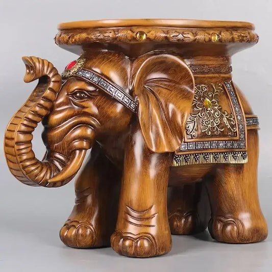 A polished wooden carved elephant wealth attracting ornaments stool with gold silver inlays and a red gemstone on forehead