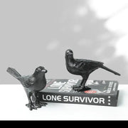 Black iron bird decoration with detailed feather texture and sturdy legs positioned on a book for living room display