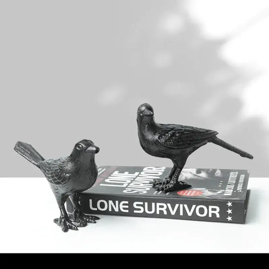 Black iron bird decoration with detailed feather texture and sturdy legs positioned on a book for living room display