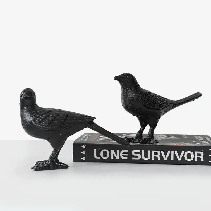 Two matte black cast iron bird figurines with detailed feathers and elongated tails for elegant living room decoration