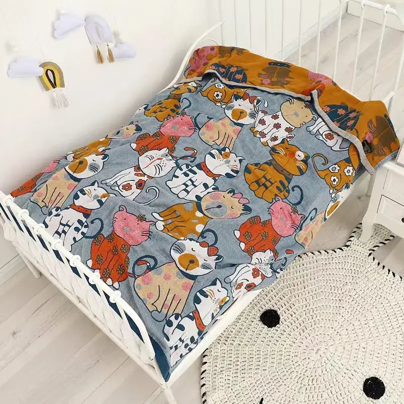 A cozy gray pure cotton gauze towel blanket with cat cartoon animal patterns draped over a white metal bed frame