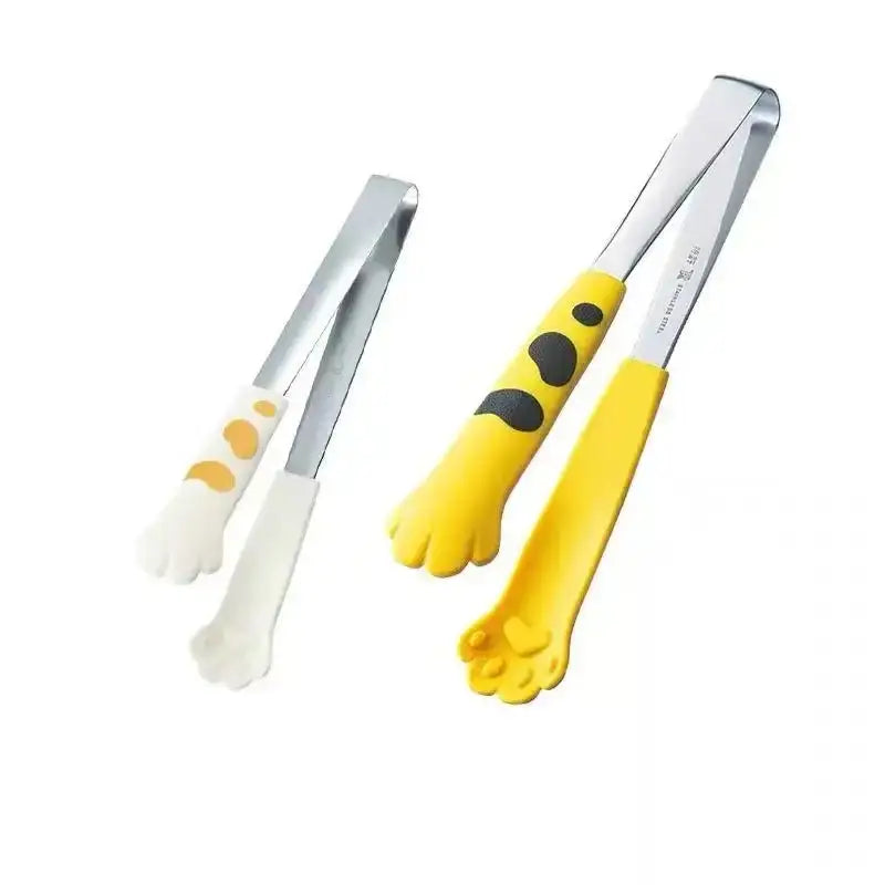 A pair of cat paw stainless steel food tongs with silicone handles in white orange and yellow black spotted colors