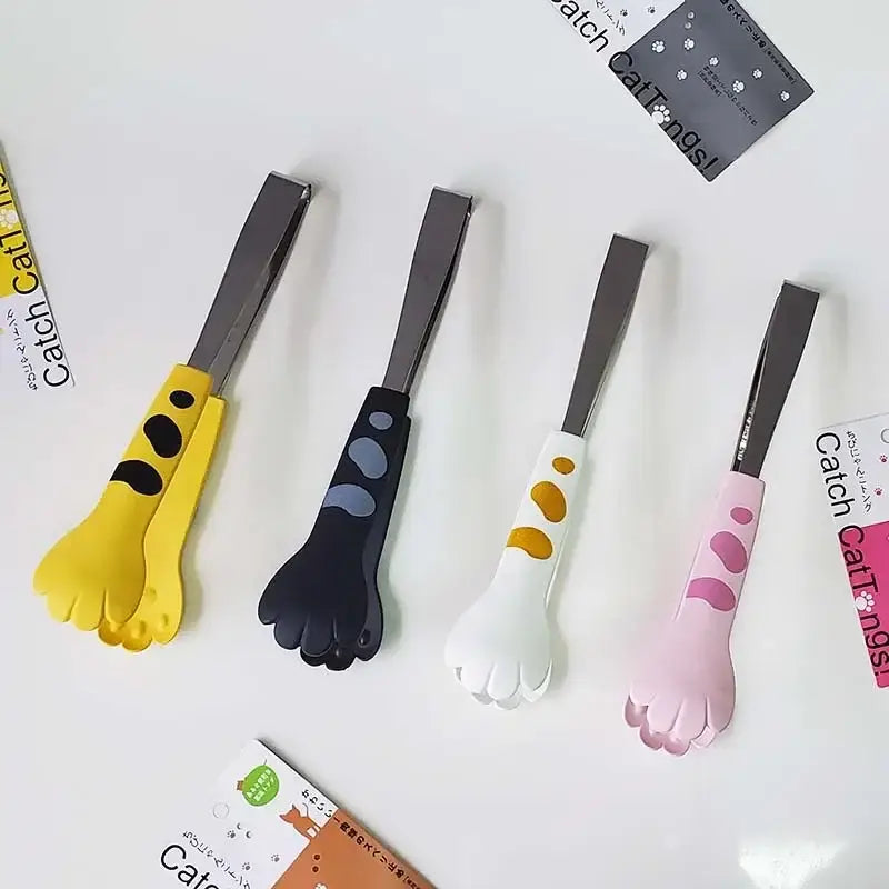 Set of four cat paw stainless steel food tongs with yellow black white and pink silicone grips for kitchen use
