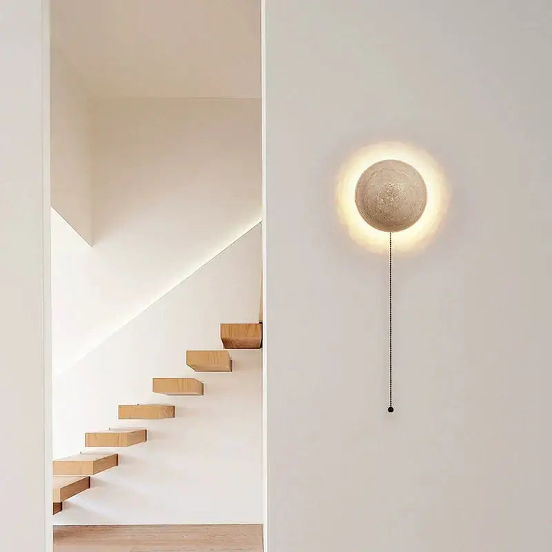 Minimalist concrete cave stone yellow wall lamp with warm glow and black pull chain for bedroom ambiance decorbites cave stone