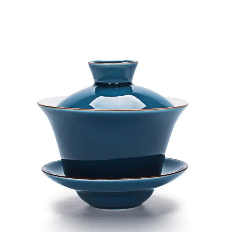 Deep teal ceramic gaiwan tea set with gold rim and matching lid and saucer in elegant celadon tea tureen style