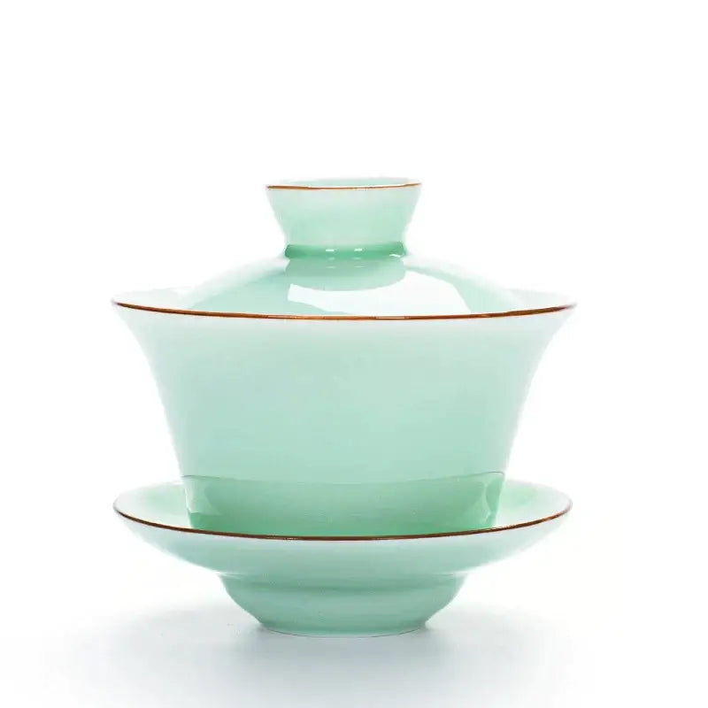A delicate celadon light blue porcelain tea set gaiwan with gold rims for elegant tea service