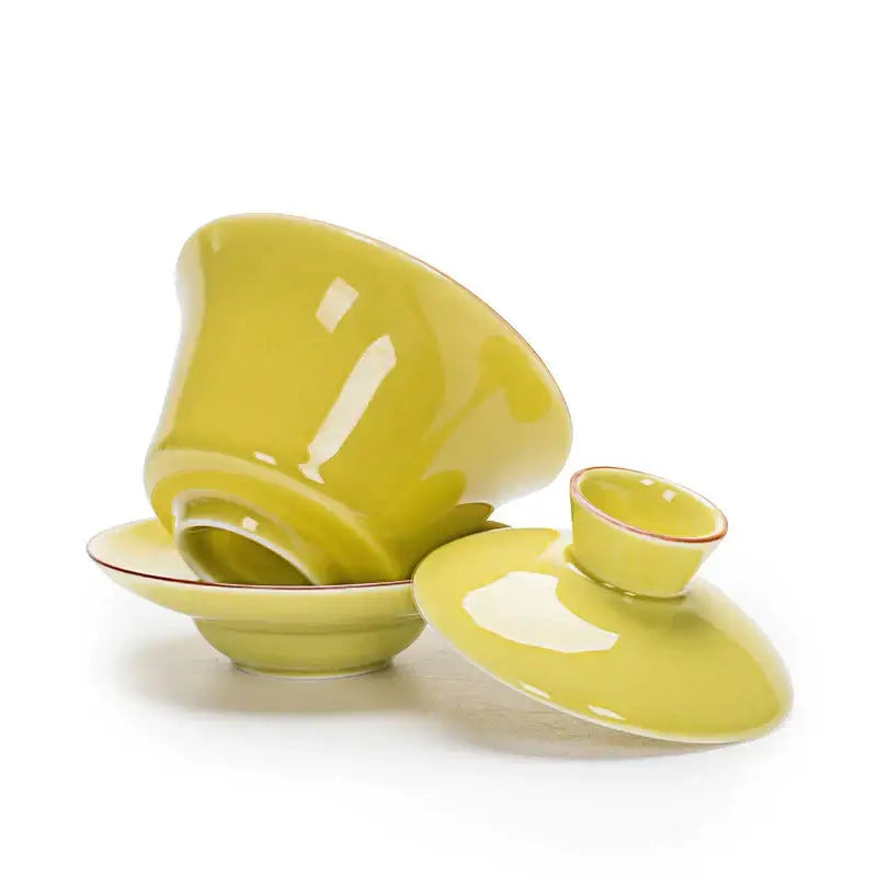 A glossy lime green ceramic gaiwan tea set with red trim paired with celadon tea tureen for elegant dining use