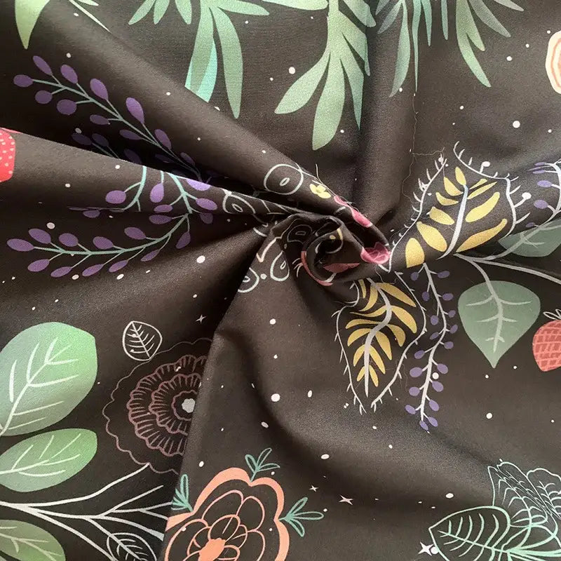 Black fabric celestial moon phase floral tapestry with vibrant green purple yellow pink leaves flowers and strawberries