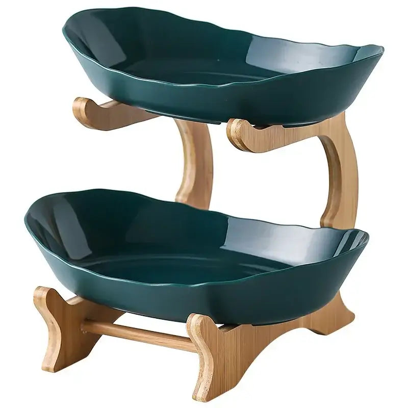Two-tiered table plates set with dark teal ceramic bowls and light wood bamboo legs for dining room use