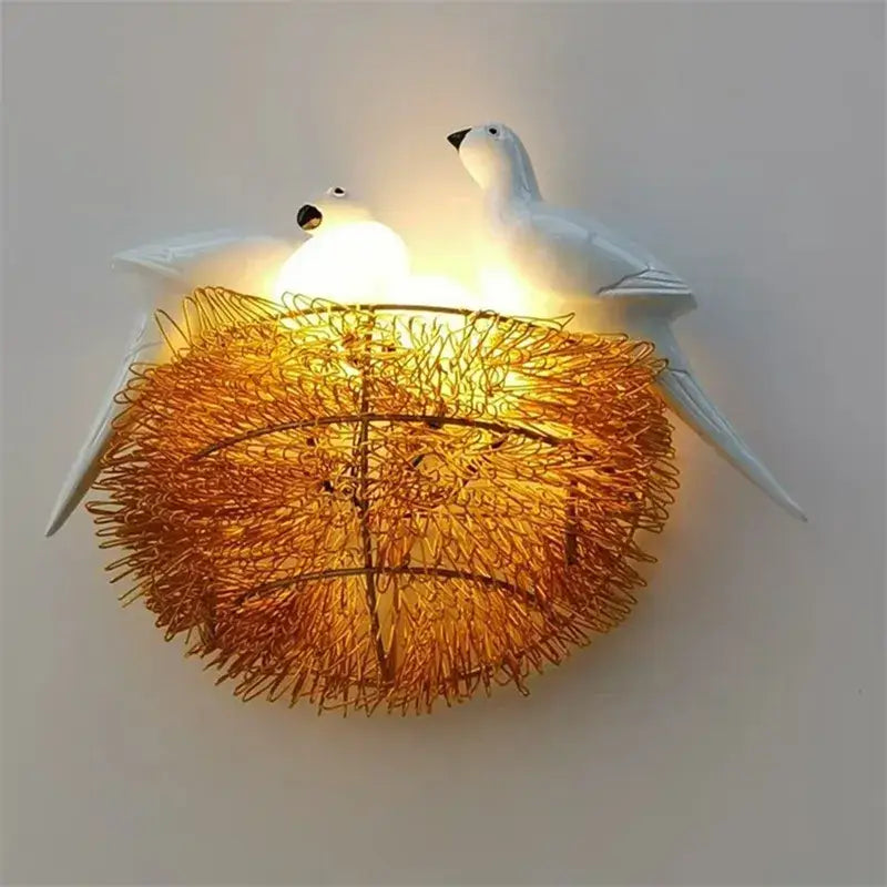 White ceramic bird led wall lamp featuring a glowing golden wire nest for bedroom sconce lighting