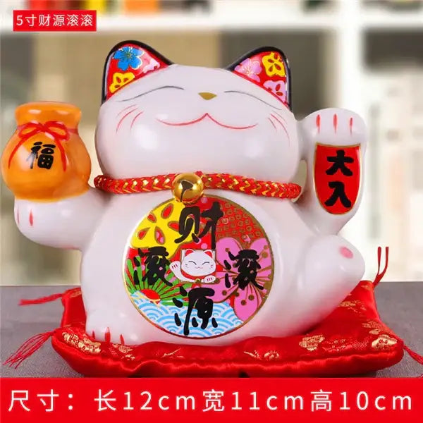 White ceramic maneki neko piggy bank with red accents holding orange money pouch and daikichi charm decorbites ceramic maneki
