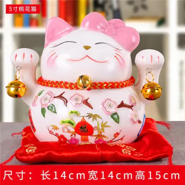 White ceramic maneki neko piggy bank with pink ears, floral patterns, and gold bells for living room decorbites ceramic maneki