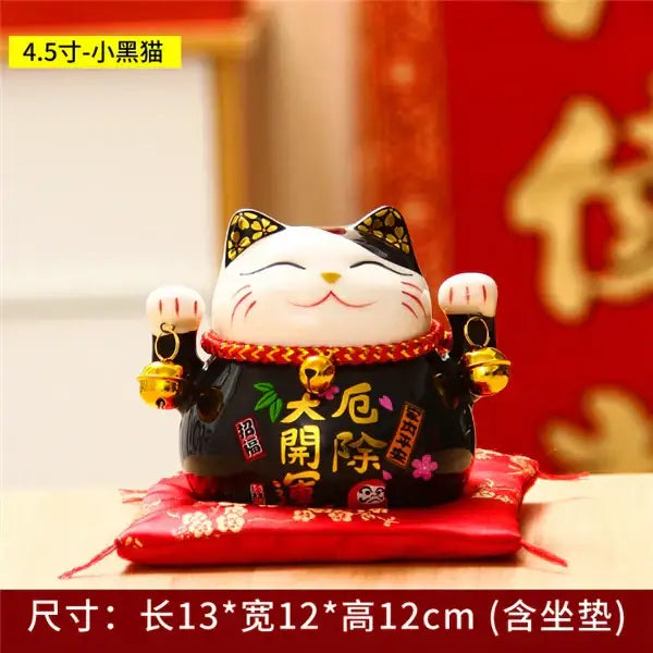 Black ceramic maneki neko piggy bank with white face gold accents and chinese characters for floral living room decor