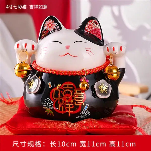 White and black ceramic maneki neko piggy bank with red floral accents and gold bells for living room decor by decorbites ceramic maneki