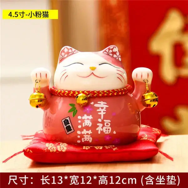 Glossy pink ceramic maneki neko piggy bank with white accents and gold bells, ideal for floral white living room decor
