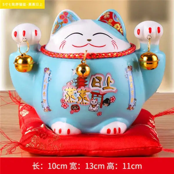 A light blue and white decorbites ceramic maneki ceramic maneki neko piggy bank with red and gold accents for living room decor