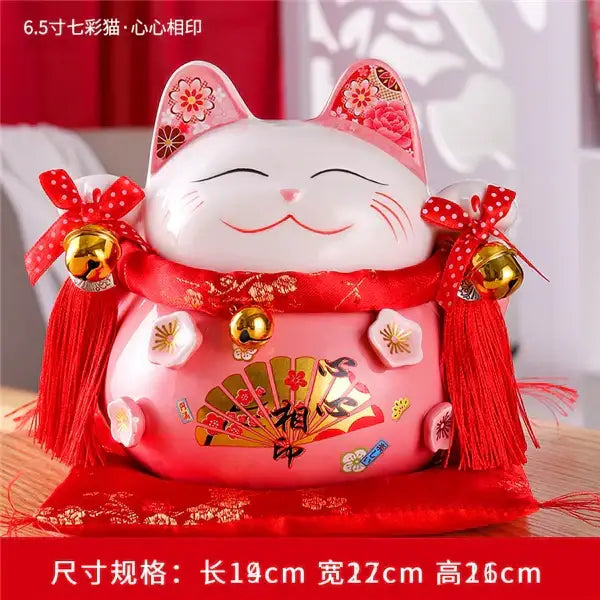 Pink ceramic maneki neko piggy bank with red ribbon gold bells and floral decor for living room decorbites ceramic maneki