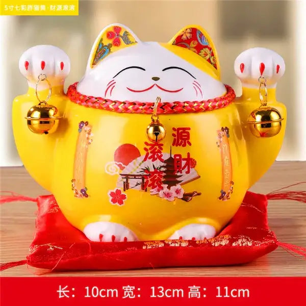 A vibrant yellow ceramic maneki neko piggy bank with white accents and floral decorbites ceramic maneki design