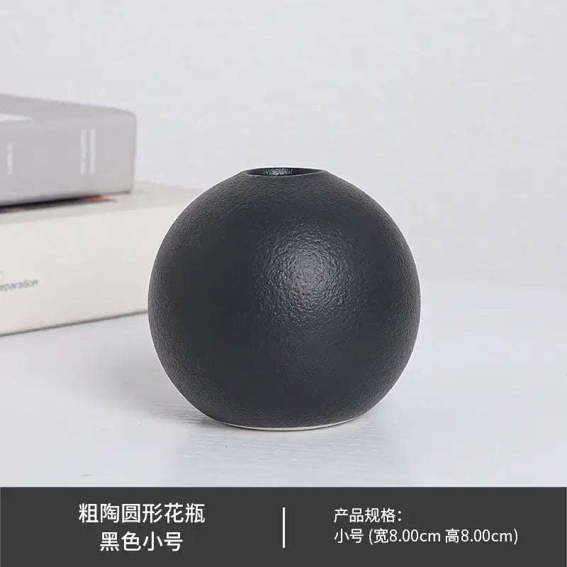 Black white ceramic round vase with a textured matte surface and small opening for decorative use