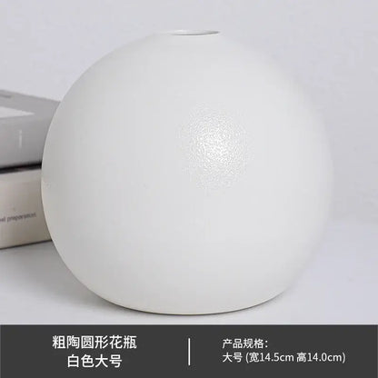 A sleek matte white ceramic round vase with a bulbous shape and subtle texture in vase black white style