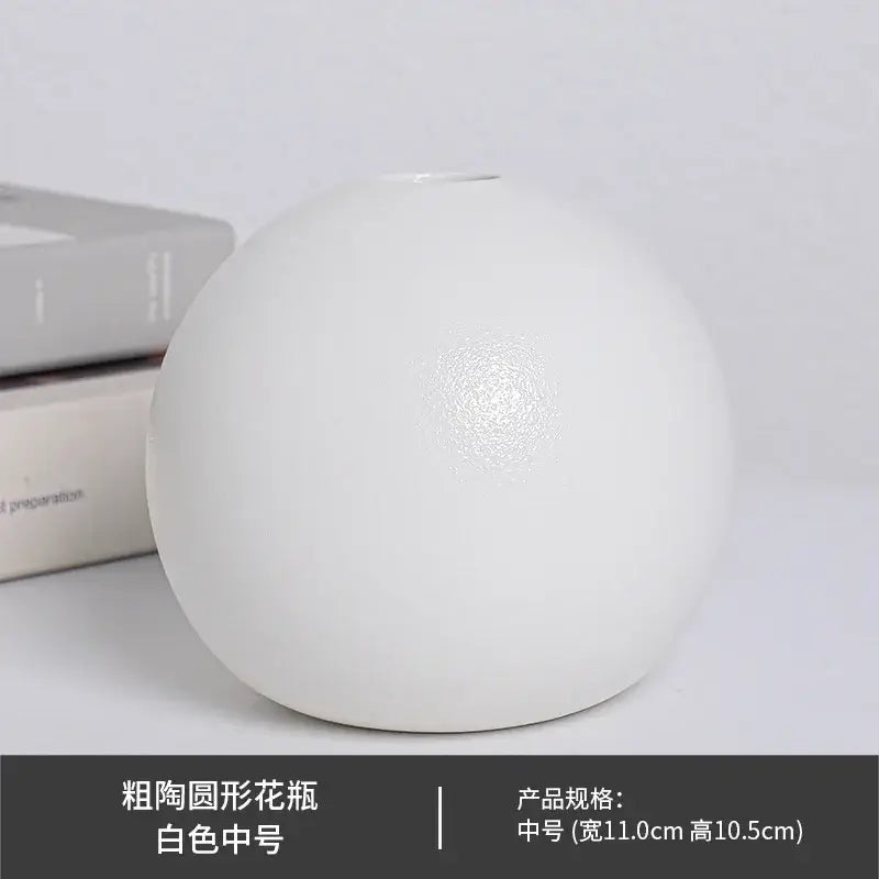 A white ceramic round vase black white with a slightly textured surface and a narrow opening at the top