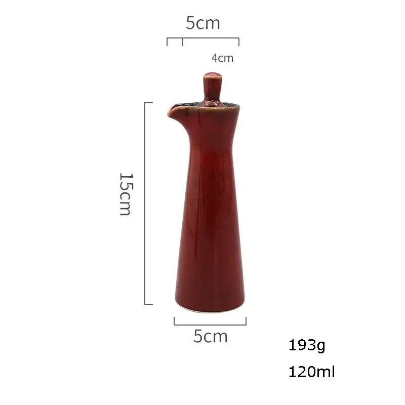 A sleek glossy red ceramic seasoning pot with tapered body and small spout from decorbites ceramic seasoning set