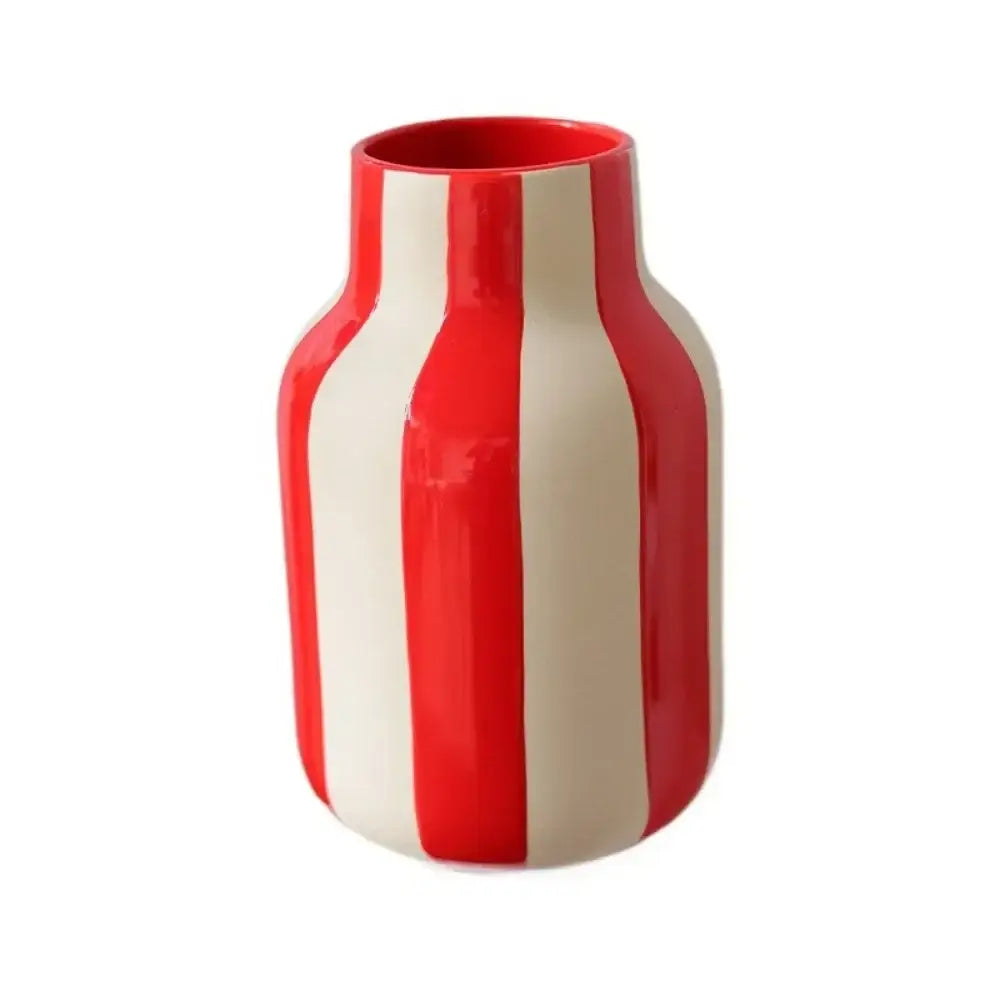 A glossy ceramic vase with bold vertical red and cream stripes in a red striped ceramic vase design