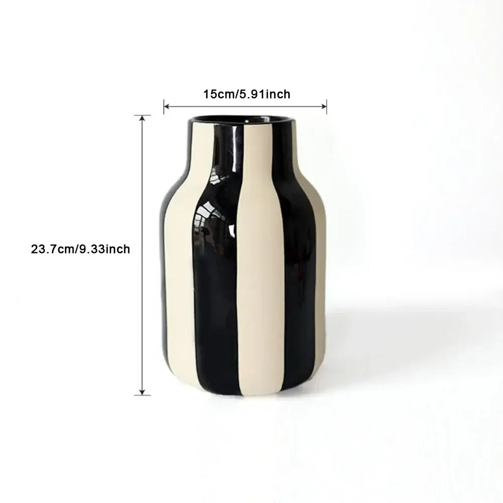 A sleek glossy ceramic vase with bold vertical black and cream stripes featuring a striped ceramic vase design