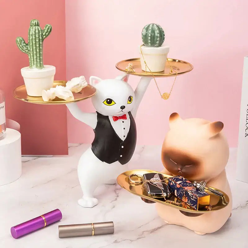 Ceramic white cat figurine dressed in black tuxedo with red bow tie holding gold trays for cat figurines storage tray