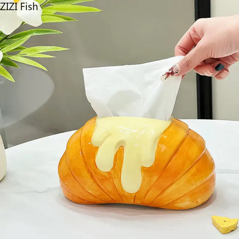 Golden ceramic tissue box shaped like a croissant with yellow icing drip decorbites croissant ceramic bedroom decor