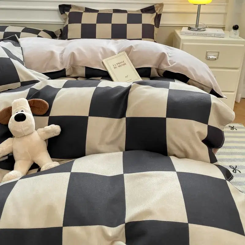 Black and cream checkered satin duvet cover set with plush stuffed dog toy resting on the bedding cover set
