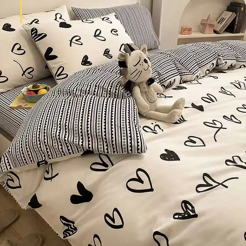 White cotton duvet cover set with black heart patterns and matching pillowcases in checkerboard black and beige satin design