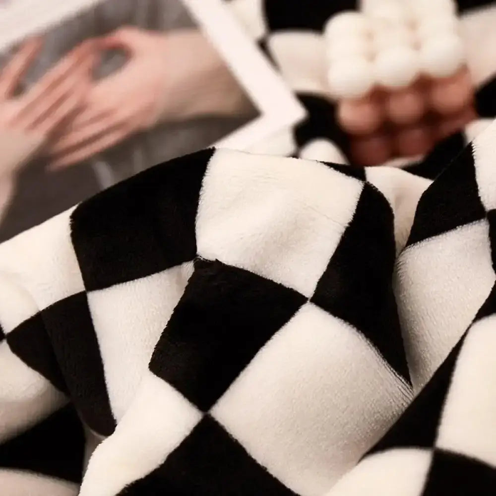 A plush black and white checkerboard lamb fleece blanket with soft velvety texture for bedroom decorbites throw